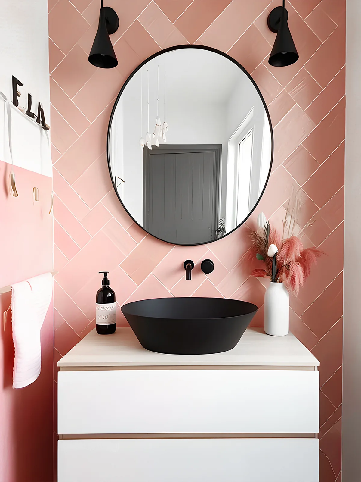 A pink and white bathroom with a black sink and mirror.