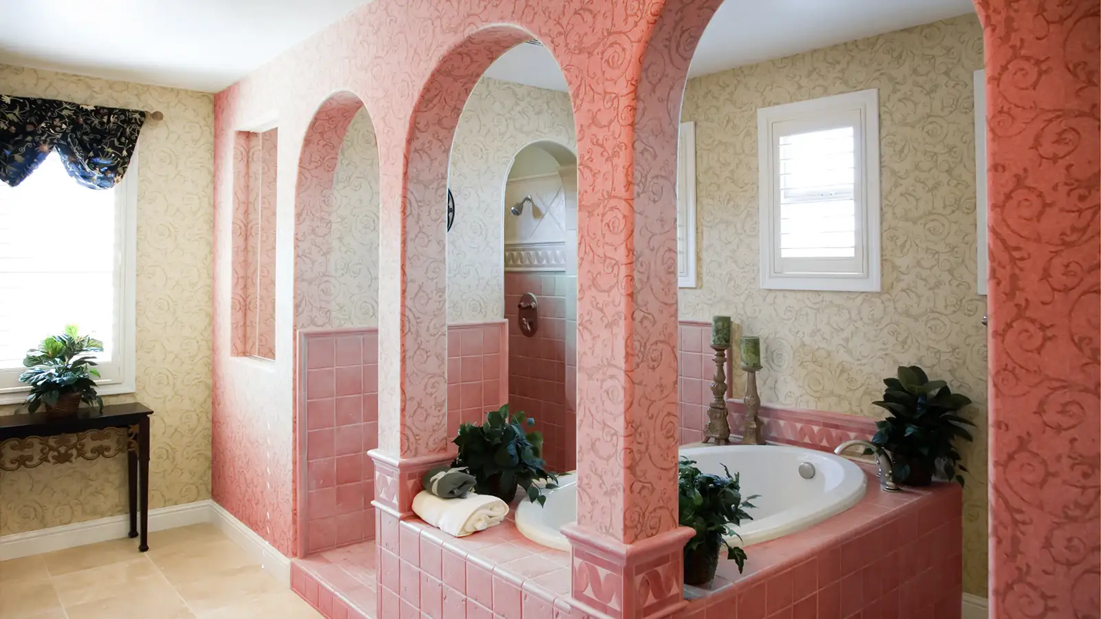 A bathroom with pink walls and arches.