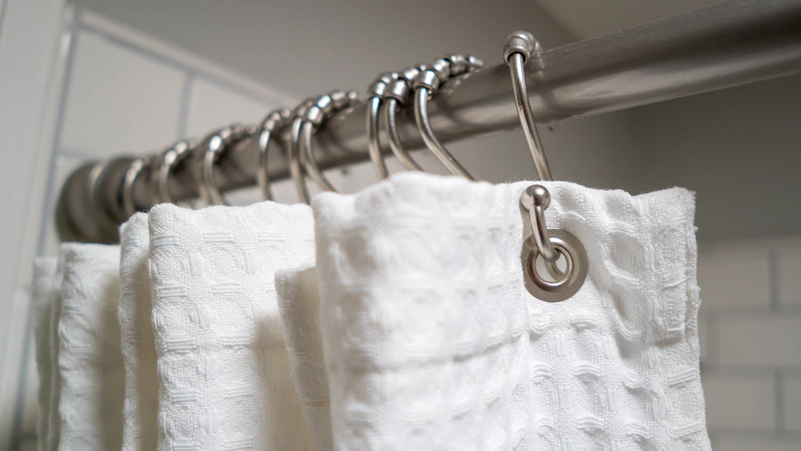 Types of Shower Curtain Hooks: White towels hanging on a shower rod.