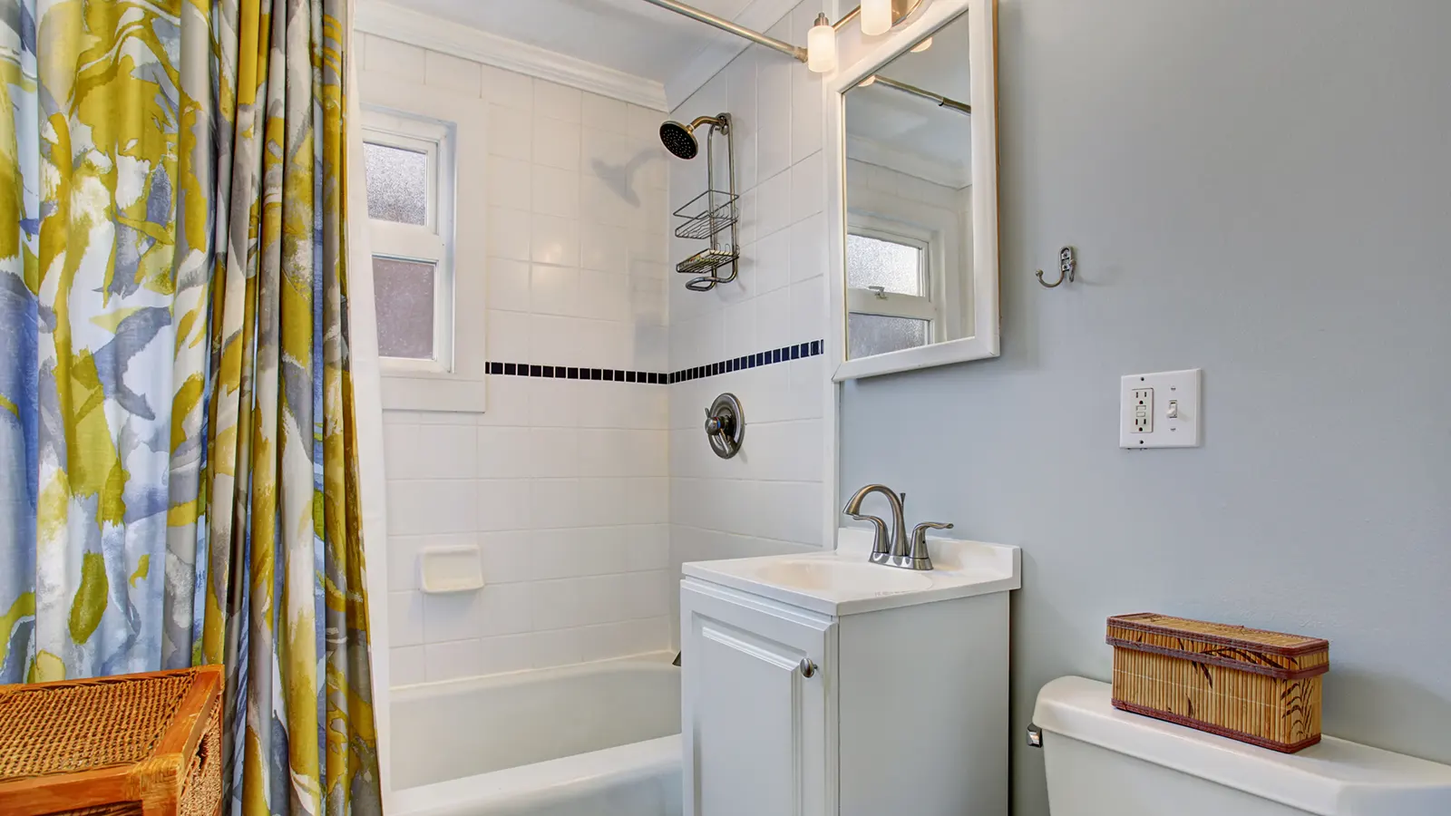 Are fabric shower curtain liners better than plastic? A bathroom with a yellow shower curtain and a toilet.
