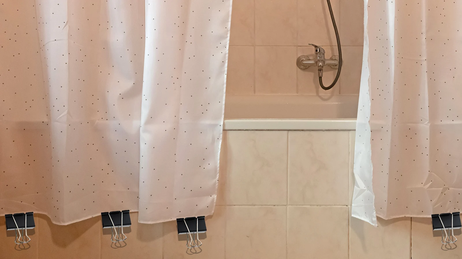 A bathroom with a shower curtain and a tub. Learn how to keep the shower curtain closed for a neat and tidy appearance.