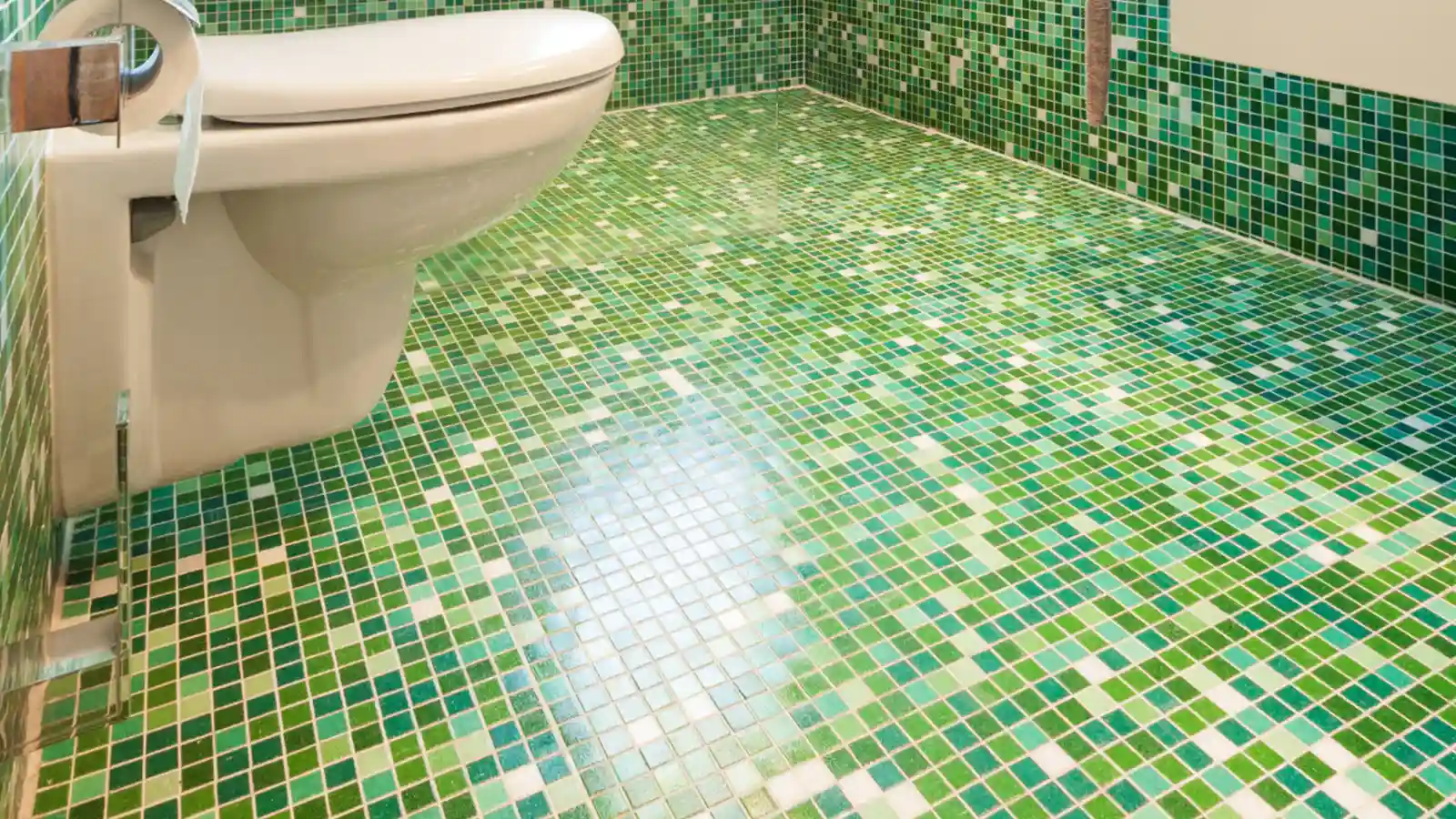 Olive green bathroom decor ideas: A green tiled bathroom with a toilet and sink.
