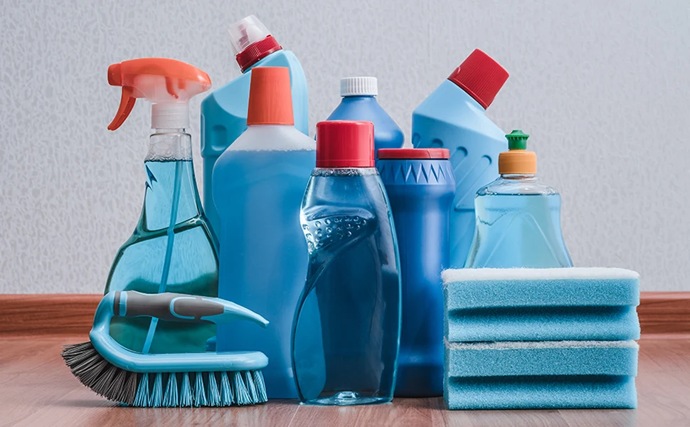 A group of blue cleaning products on a wooden floor, providing effective solutions for removing unpleasant odors from your shower curtain.