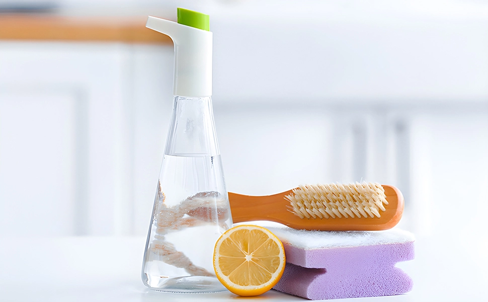 A bottle of water next to a sponge and a slice of lemon, providing refreshment while neutralizing unpleasant odors from the shower curtain.