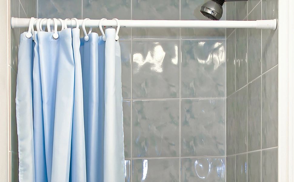 A blue shower curtain hanging in a bathroom.